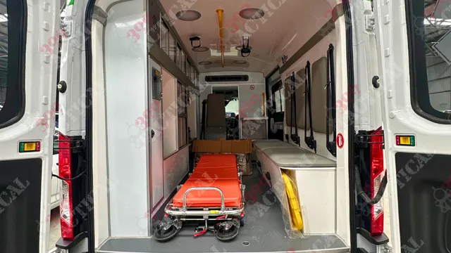 Interior de ambulancia equipada con camilla y gabinetes médicos